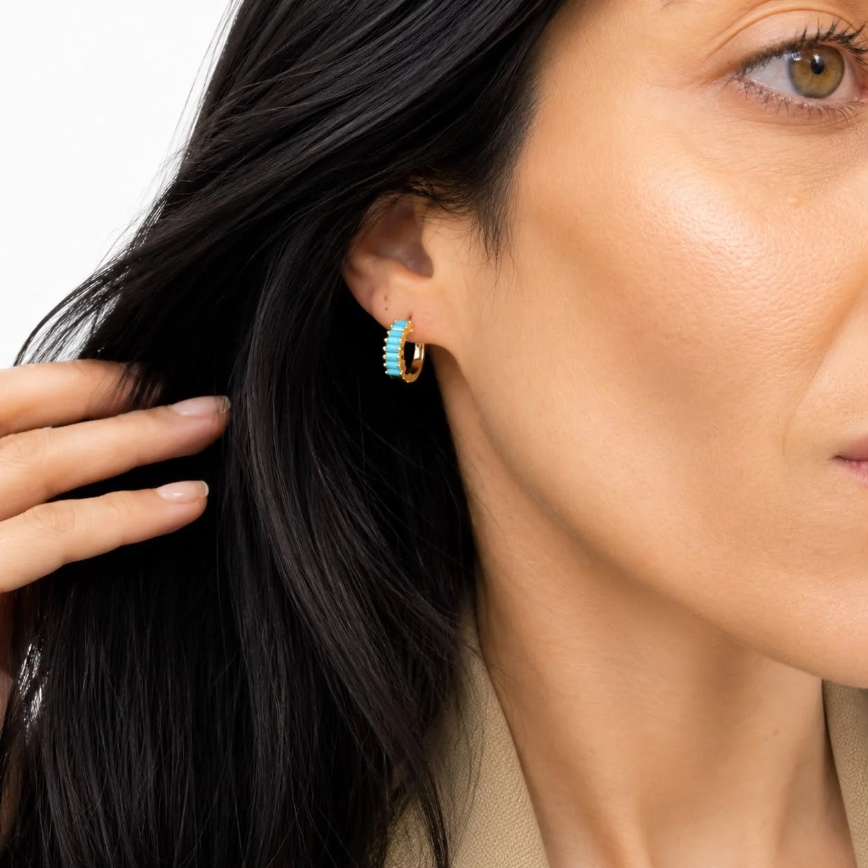 Turquoise baguette CZ huggie earrings worn on ear