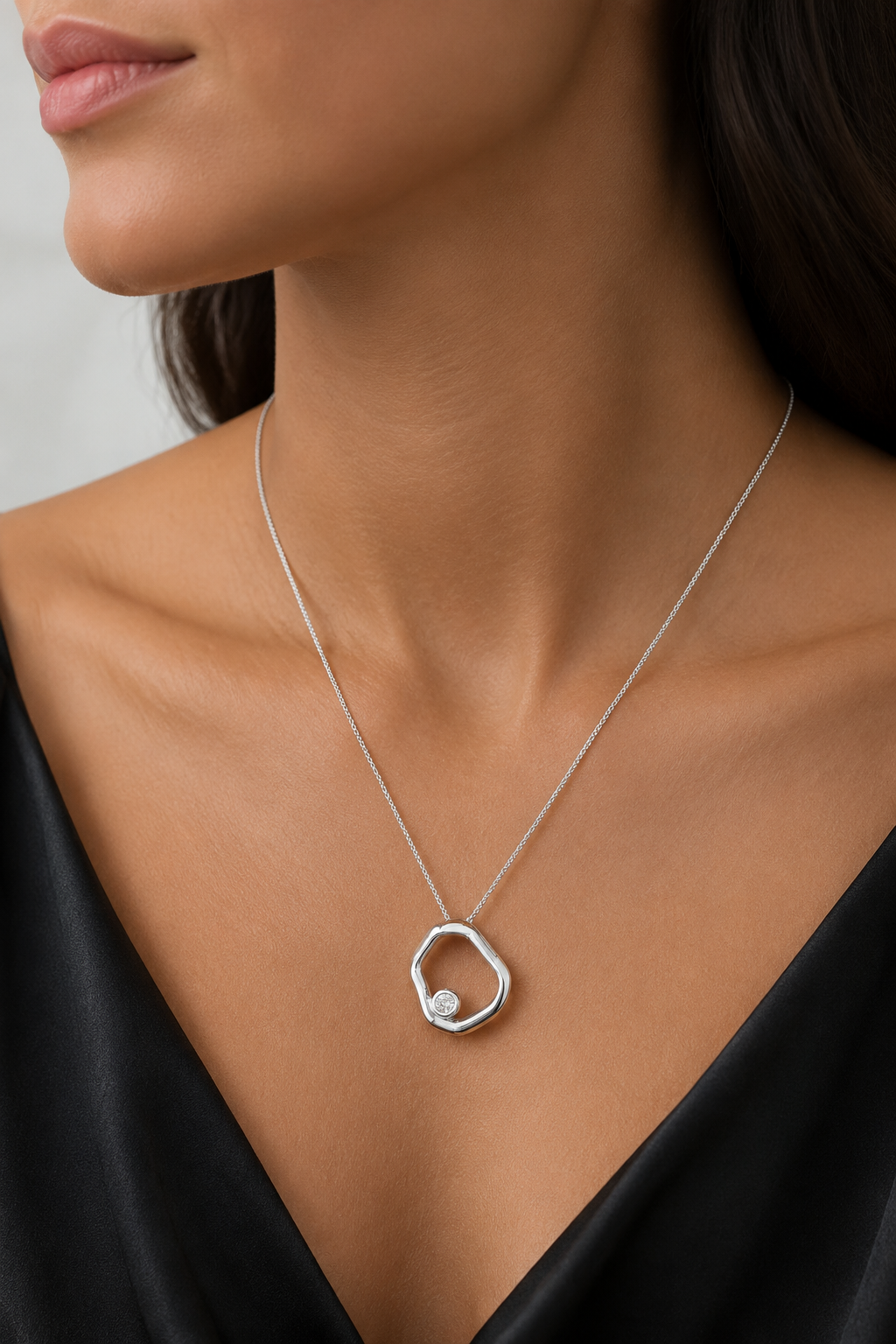 Geometric open circle pendant necklace in rhodium-filled finish worn by a model