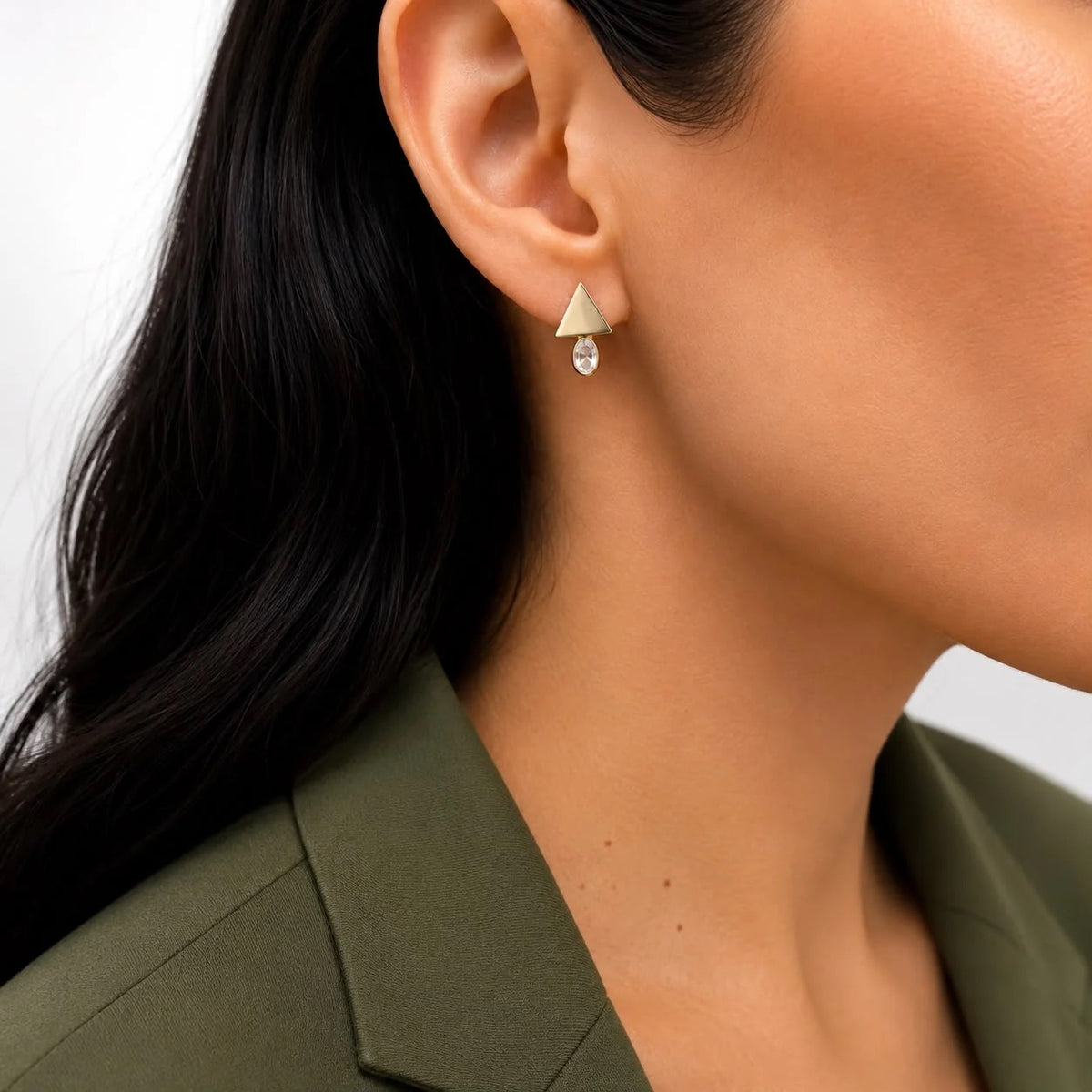 Gold-finish geometric triangle and oval cubic zirconia stud earrings worn on ear