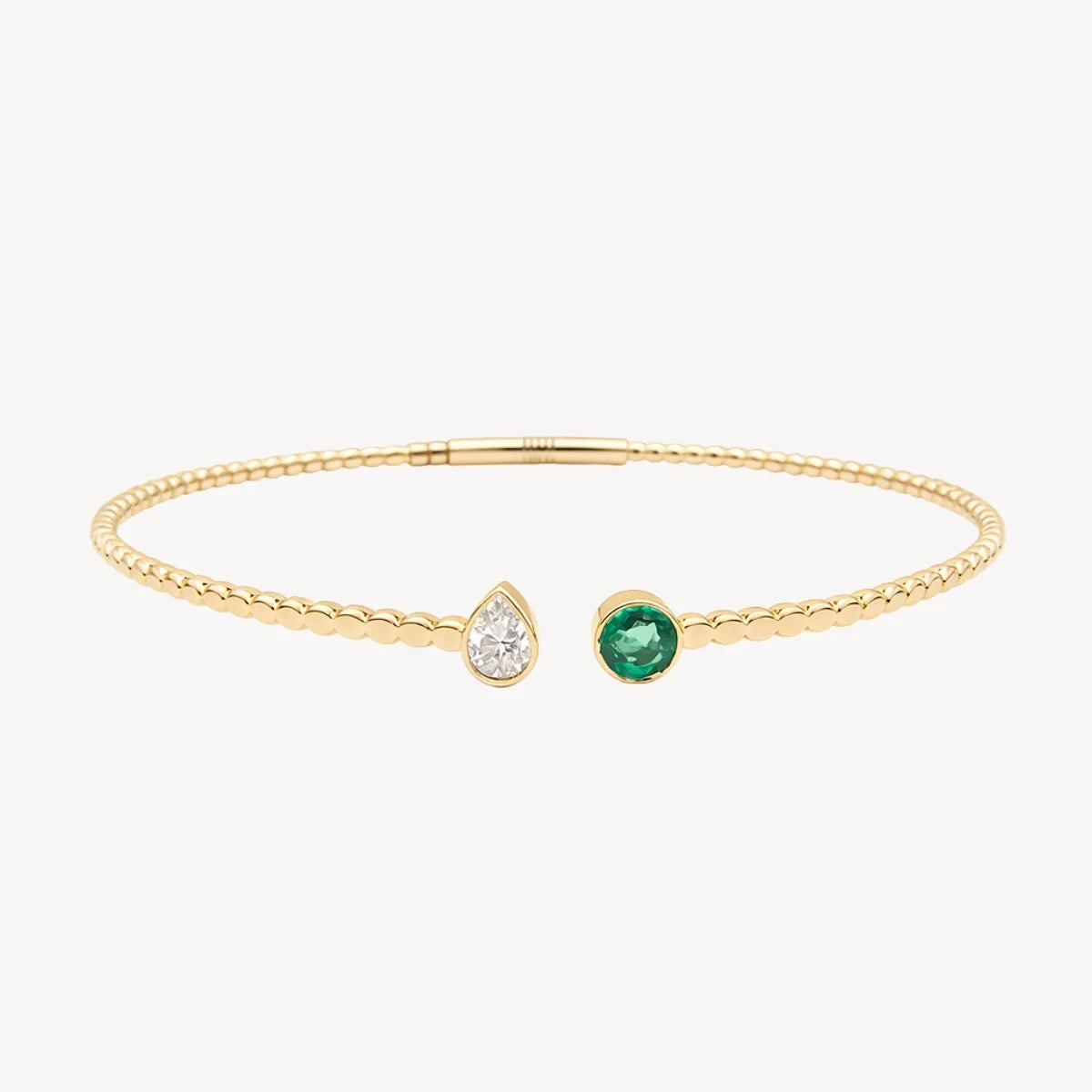 Lustrous Bracelet in 14K yellow gold with pear-cut diamond and round emerald