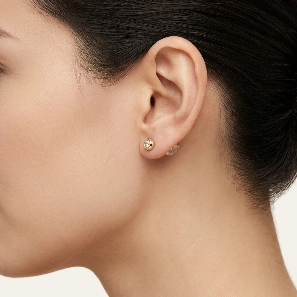 18K yellow gold bezel-set lab-grown diamond stud earring worn on ear