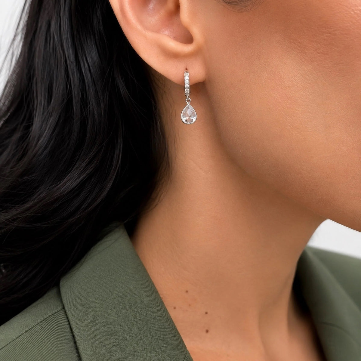 Pear-cut CZ drop huggie earring shown on ear