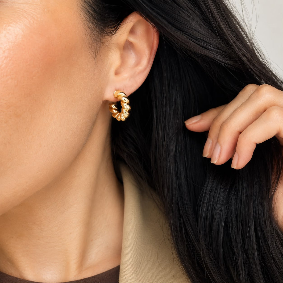 Gold twisted rope hoop earrings worn on model